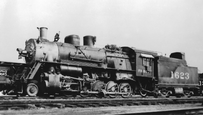 Vintage steam locomotive train on tracks in black and white photograph