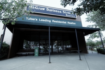 Exterior of McGraw Davisson Stewart Realtors office building in Tulsa with trees in foreground