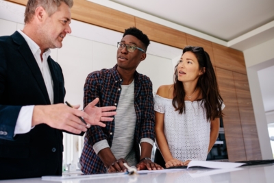 Real estate agent discussing property details with a couple indoors