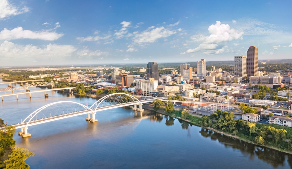 Cityscape of Little Rock with river views and bridges under a clear blue sky