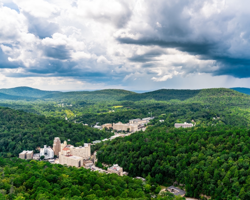 Aerial view of lush green landscape with buildings and cloudy sky in Hot Springs National Park Arkansas