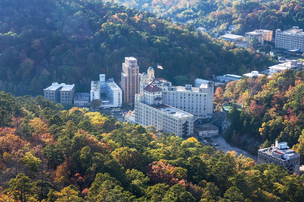 Aerial view of historic hotel surrounded by lush autumn forest in Hot Springs Arkansas