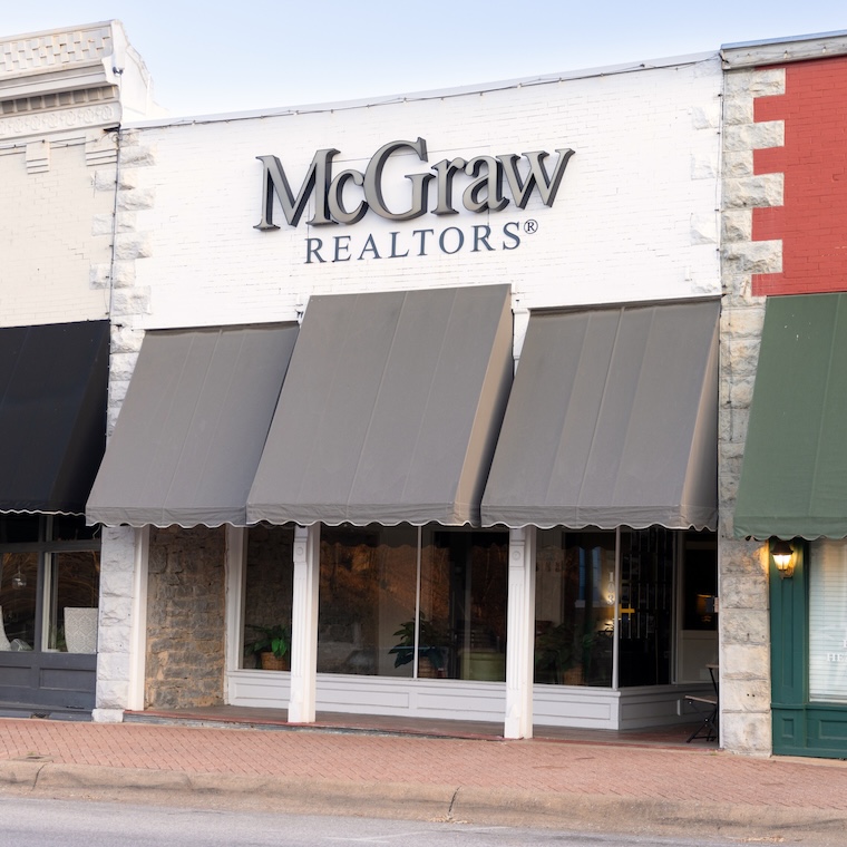 Real estate office storefront with large awnings on a small town street